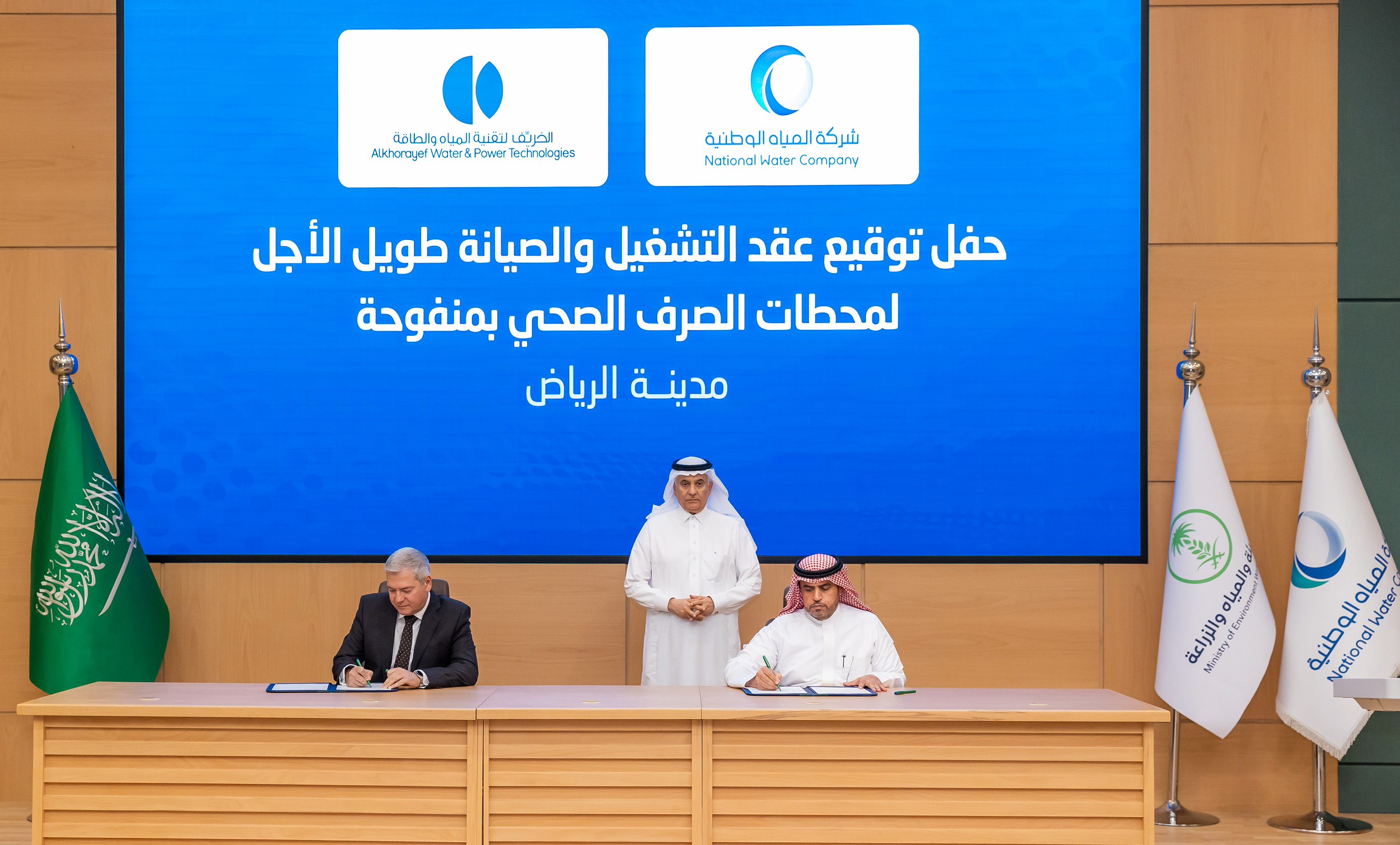 الوزير الفضيلي يتوسط رئيس شركة المياه الوطنية وممثل شركة الخريف خلال توقيع عقد.jpg